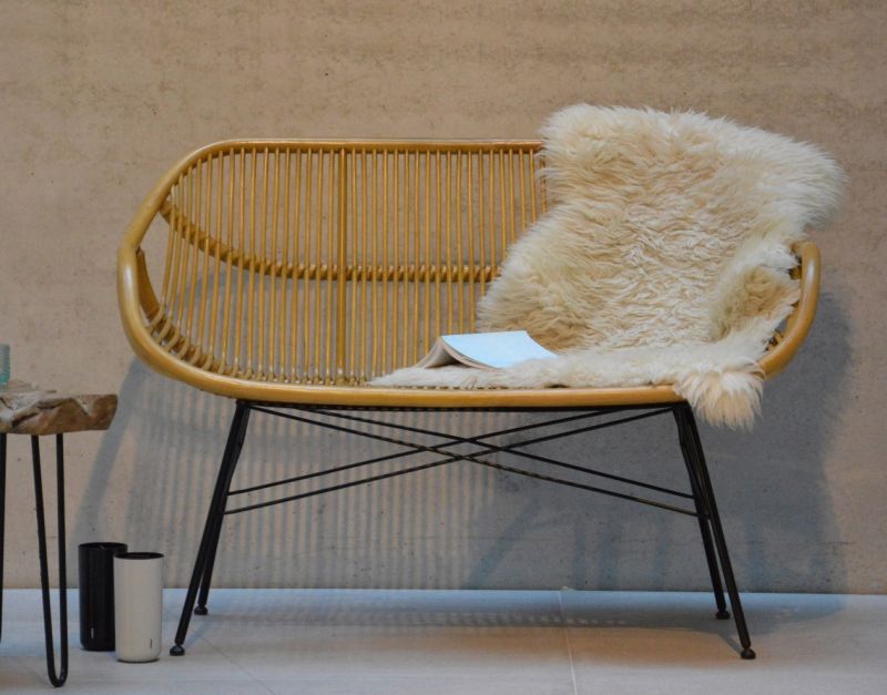 Yara Bank von Jan Kurtz, 2-Sitzer Gartenbank aus Rattan mit Schaffell und Buch.